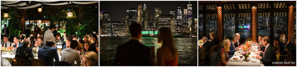 A group of people at a river cafe at night with a view of the city.