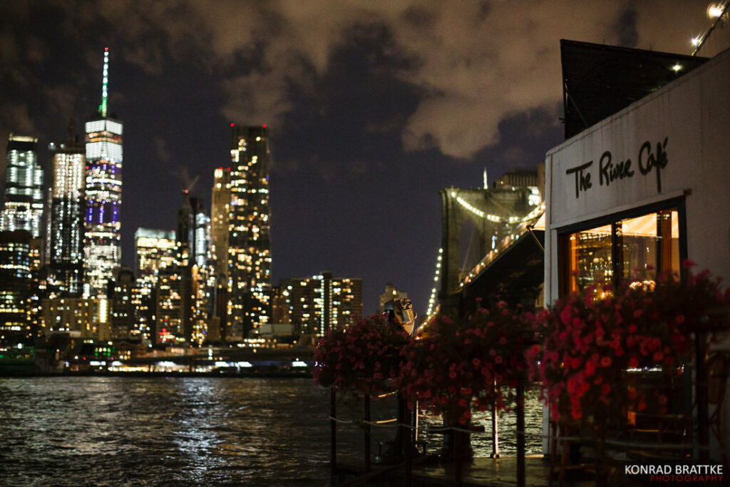 A restaurant with a view of the brooklyn skyline at night.