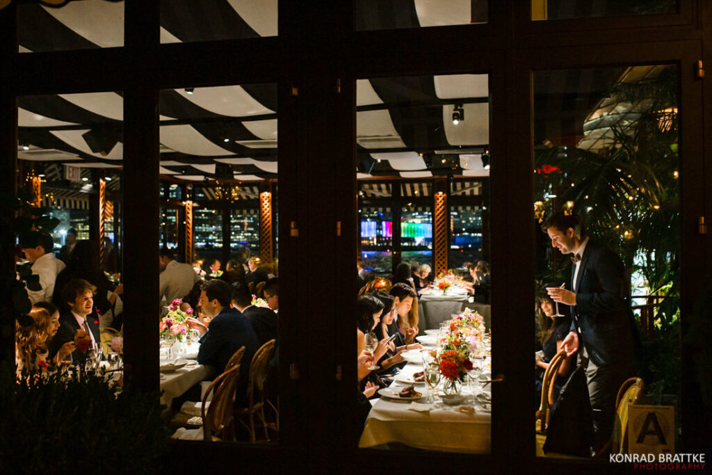 A group of people dining at the river cafe at night.