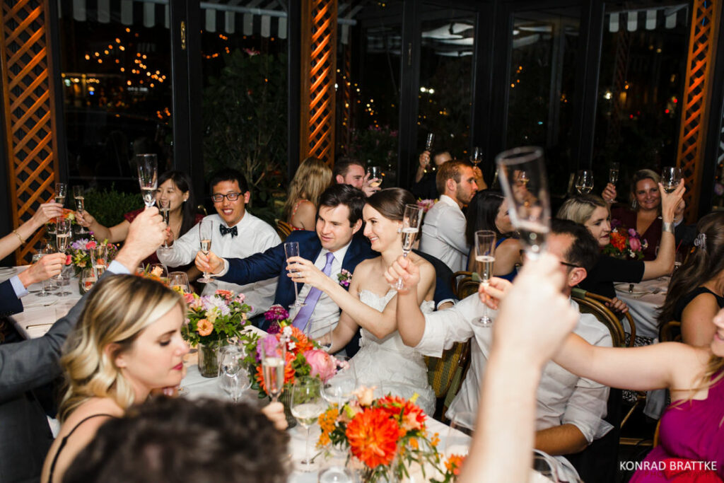 A group of people toasting at a River Cafe wedding reception.