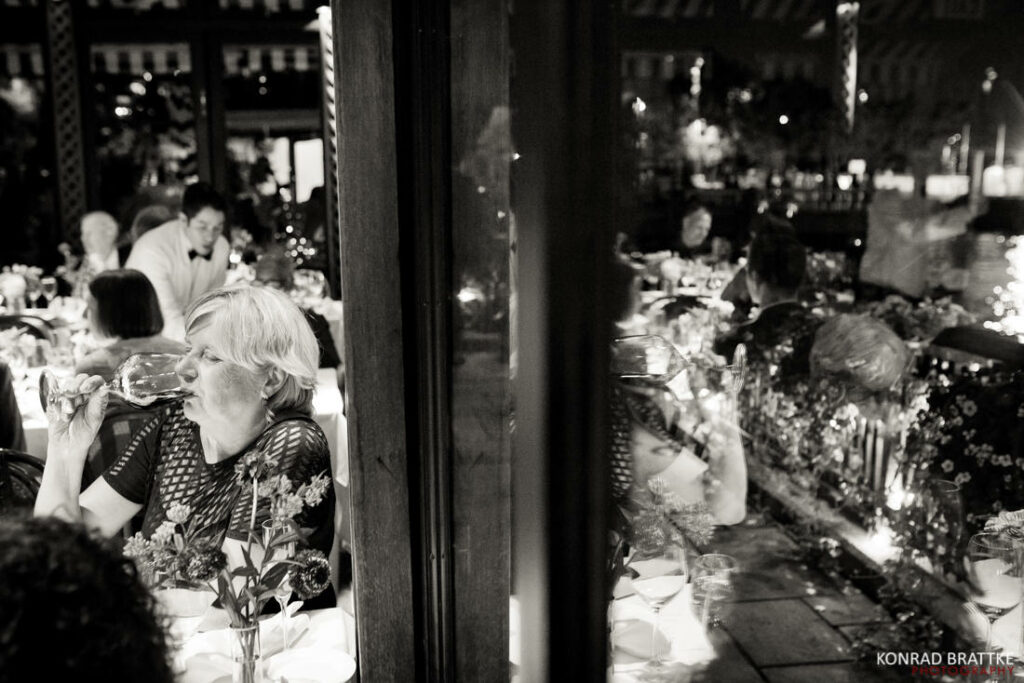 A black and white photo of a group of people at the river cafe.