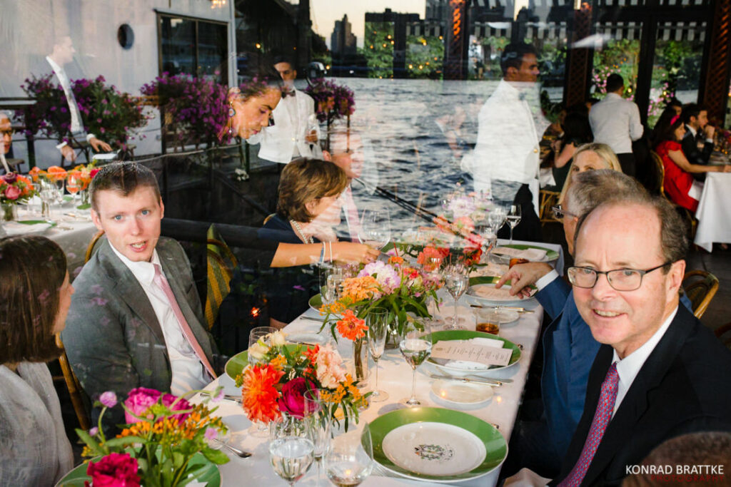 A group of people sitting at a table in the river cafe.