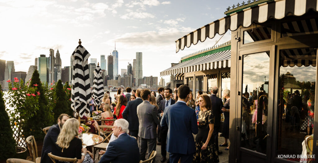 A group of people at the river cafe restaurant with a view of New York City.