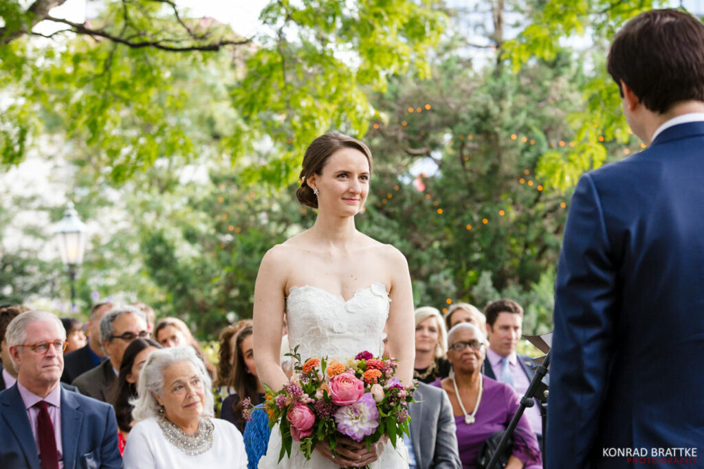 A bride and groom look at each other during their outdoor wedding ceremony at the river cafe.
