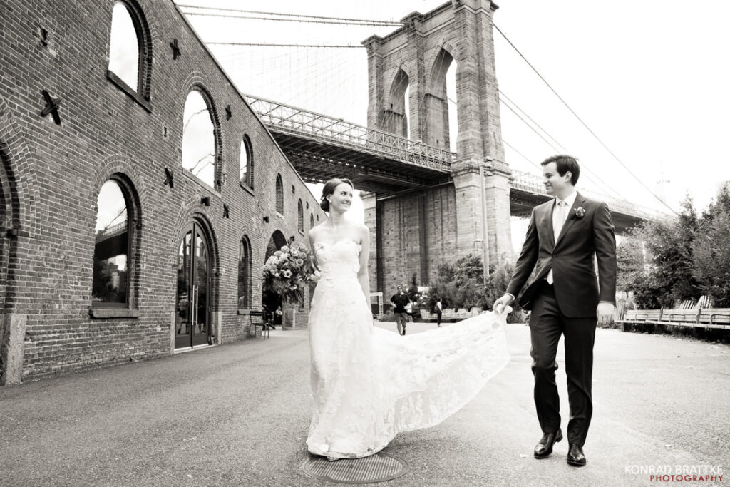 A bride and groom walking near the Brooklyn Bridge after their reception at River Cafe.