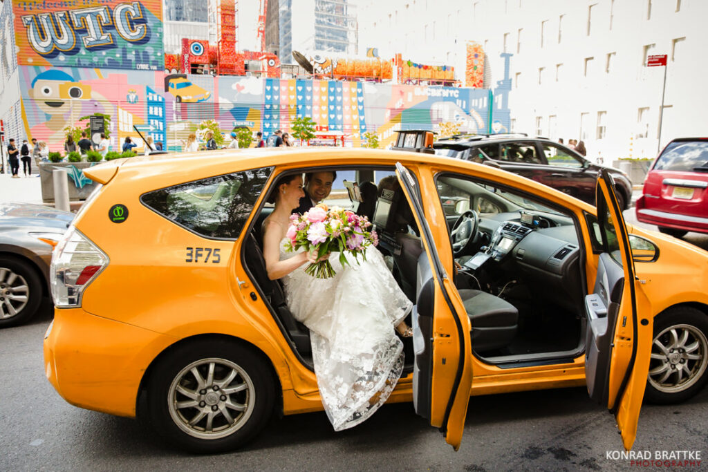 A bride is getting into a taxi cab outside in Manhattan.