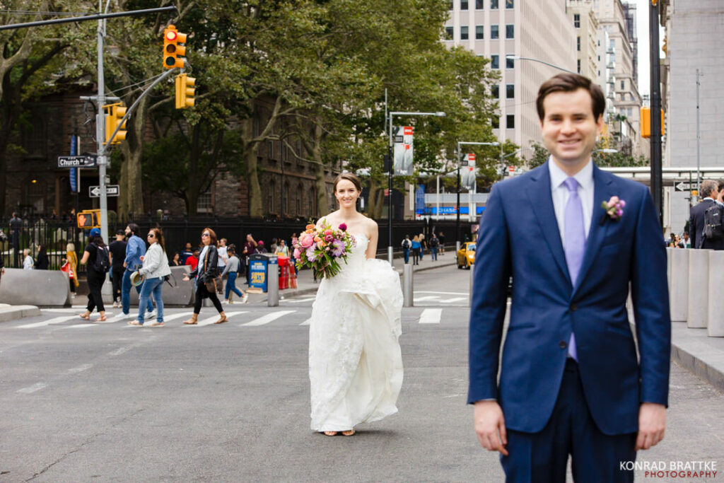 A bride and groom standing in the middle of a New York City street.