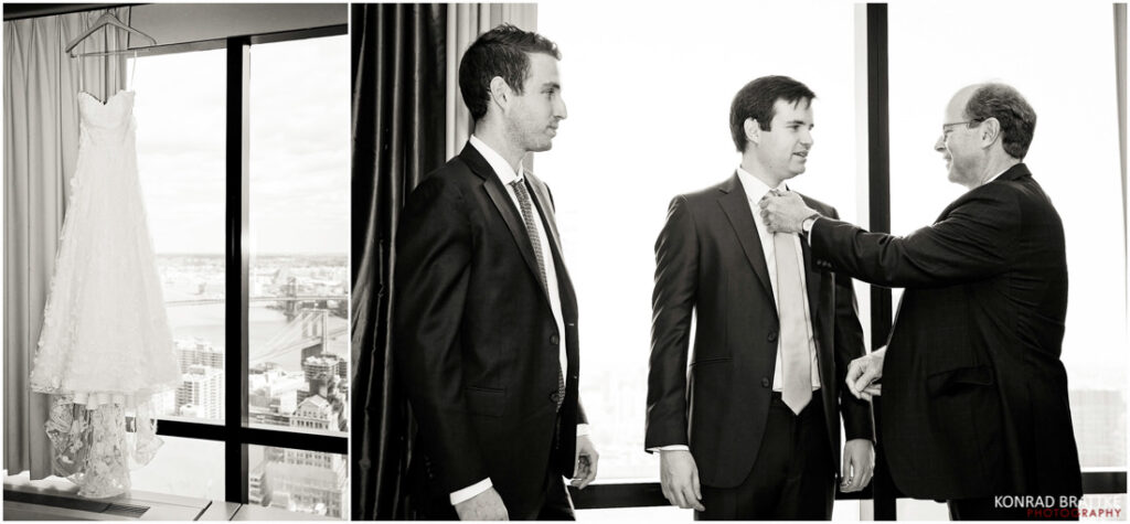 A man in a suit is putting on a tuxedo in front of a window.