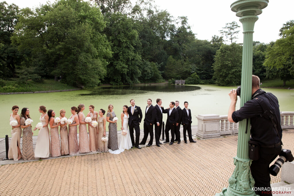 A group of bridesmaids and groomsmen posing in front of a picturesque pond, captured by a talented Maryland wedding photographer.