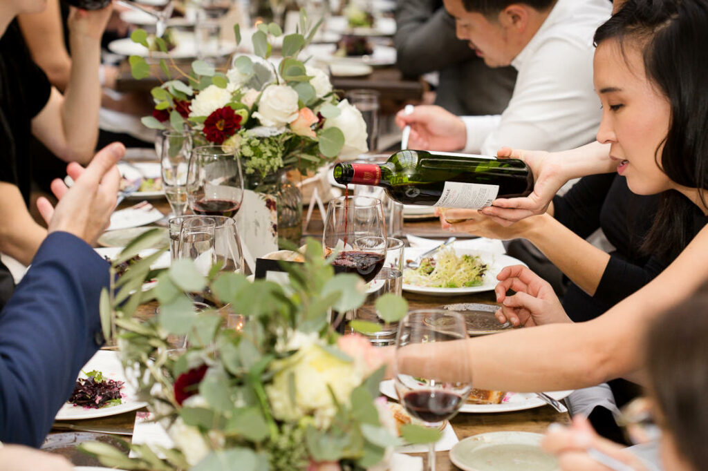 A group of people drinking wine at a dinner party at The Milling Room.