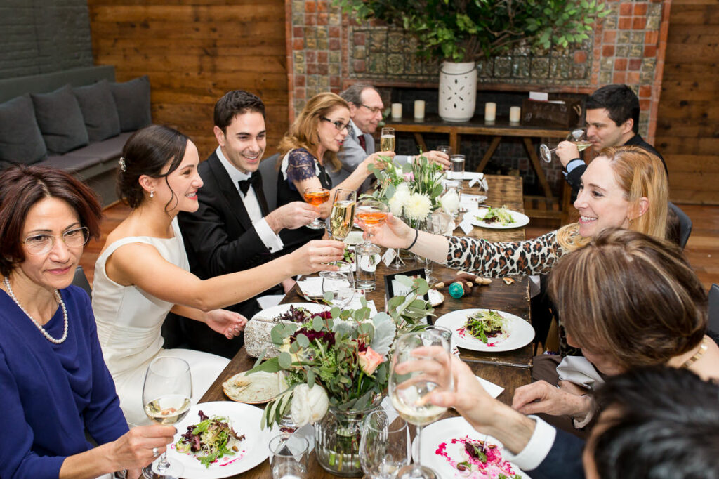 A group of people toasting at a dinner table at The Milling Room.