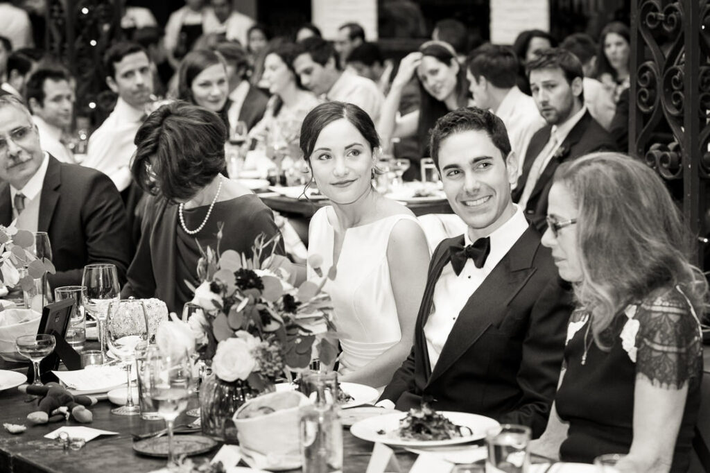 A black and white photo of a group of people sitting at a table.