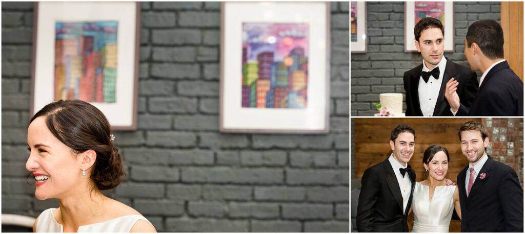 A bride and groom smiling at each other in front of a brick wall.