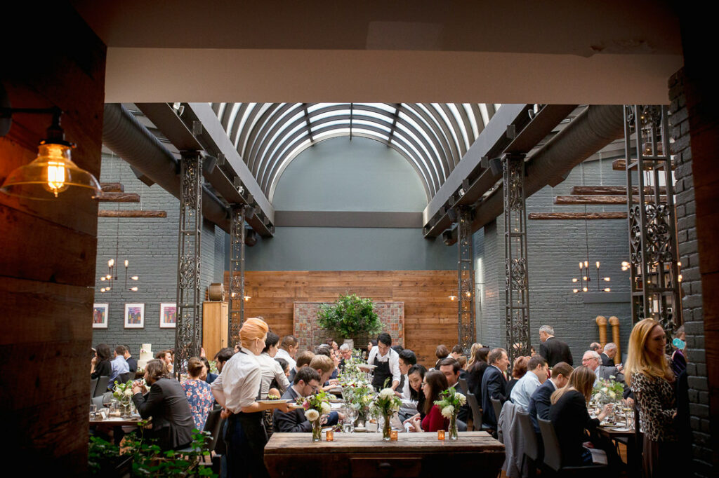 A wedding reception in a large room at The Milling Room restaurant with tables and chairs.