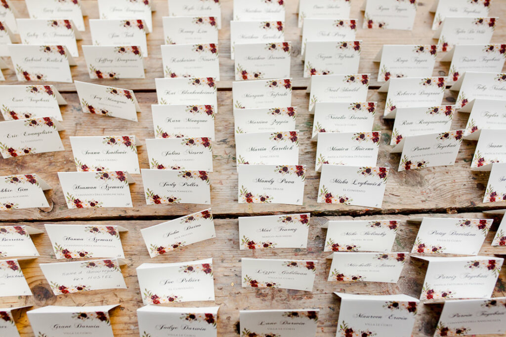 A table full of place cards with roses on them.