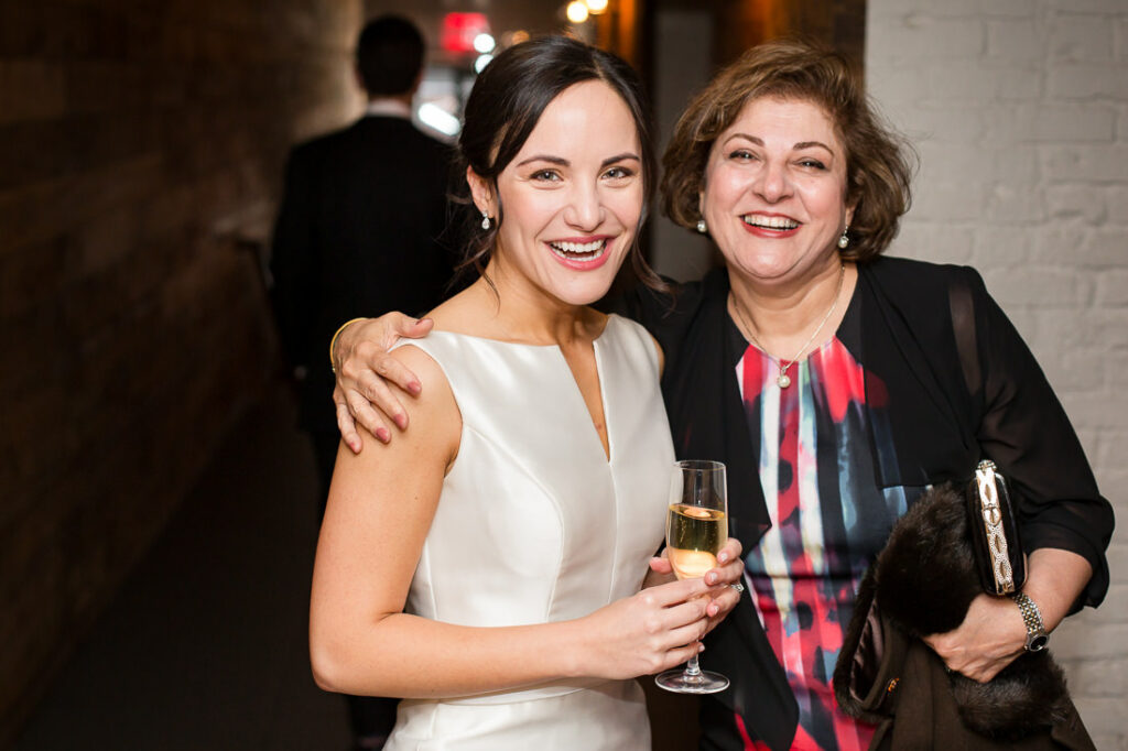 Two women posing for a photo at a wedding.