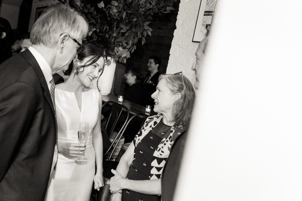A black and white photo of a group of people talking.