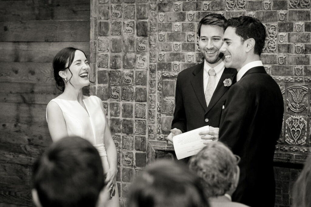 A bride and groom laughing during their wedding ceremony.