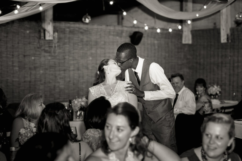 A bride and groom sharing a kiss at a wedding reception at Bacchus Bistro.
