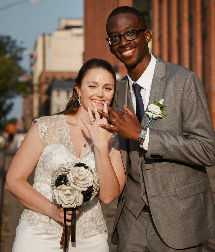 A bride and groom posing for a picture in Dumbo after their wedding ceremony.