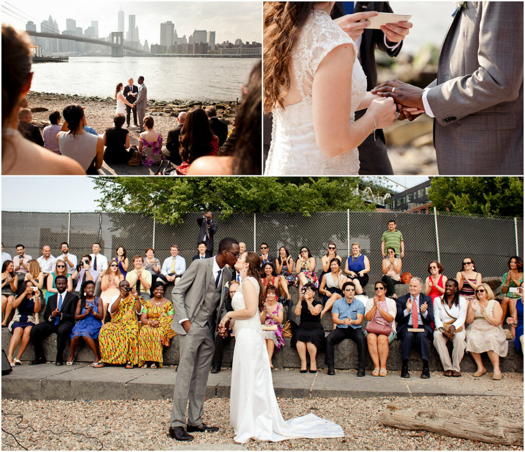 A bride and groom kiss during the wedding ceremony in Dumbo in front of a crowd of people.