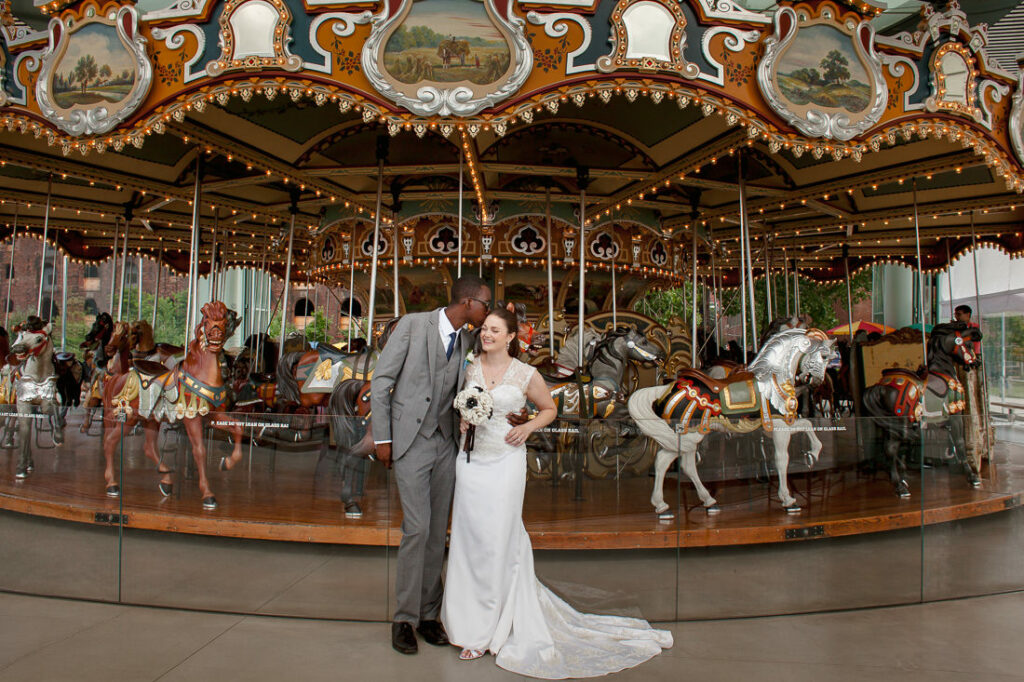 In Dumbo, a bride and groom stand gracefully in front of a carousel, radiating love and joy.