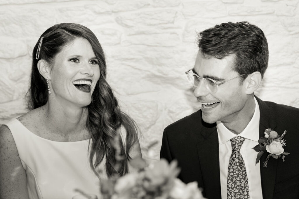 A bride and groom laughing at each other at the New York Botanical Garden.