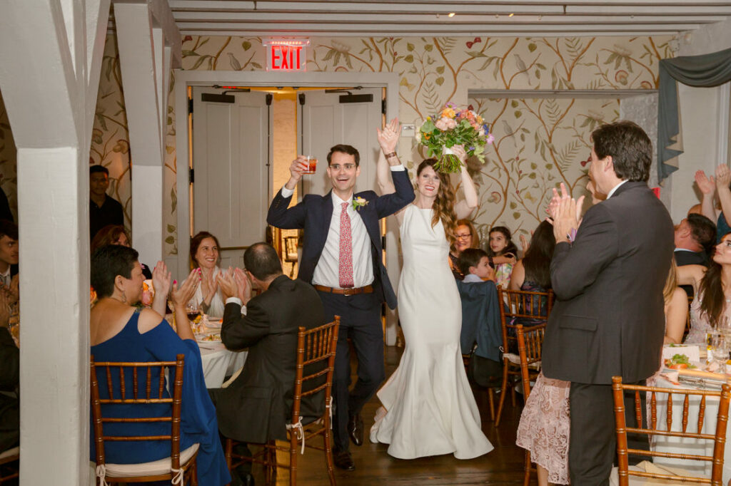 A bride and groom walk out of a wedding reception at the New York Botanical Garden.