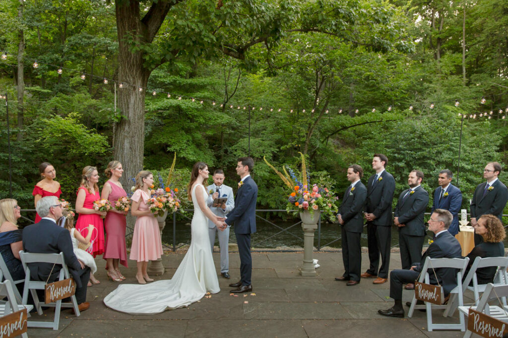 A picturesque wedding ceremony at the New York Botanical Garden, nestled in enchanting woods, with a radiant bride and groom exchanging vows.