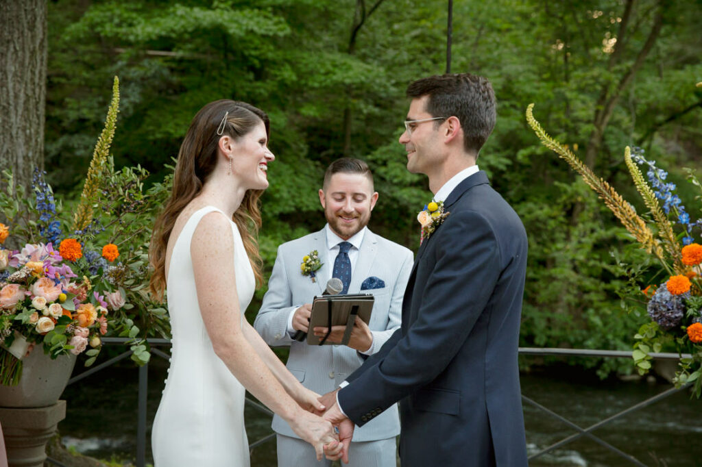 A bride and groom exchange vows in front of a waterfall at the New York Botanical Garden.