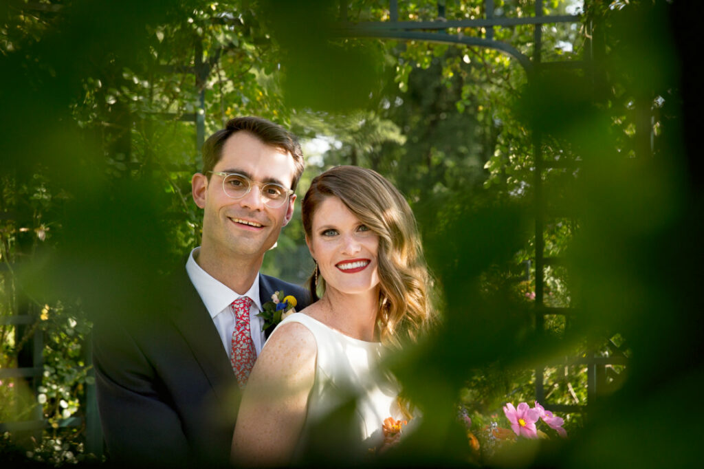 A newlywed couple posing for a photo in the enchanting New York Botanical Garden.