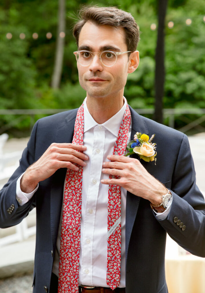 A man wearing a suit and tie at a wedding.