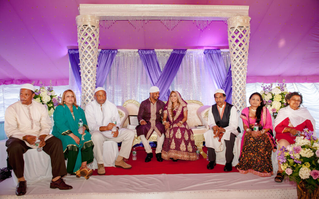 A group of people posing for a nikah ceremony picture.