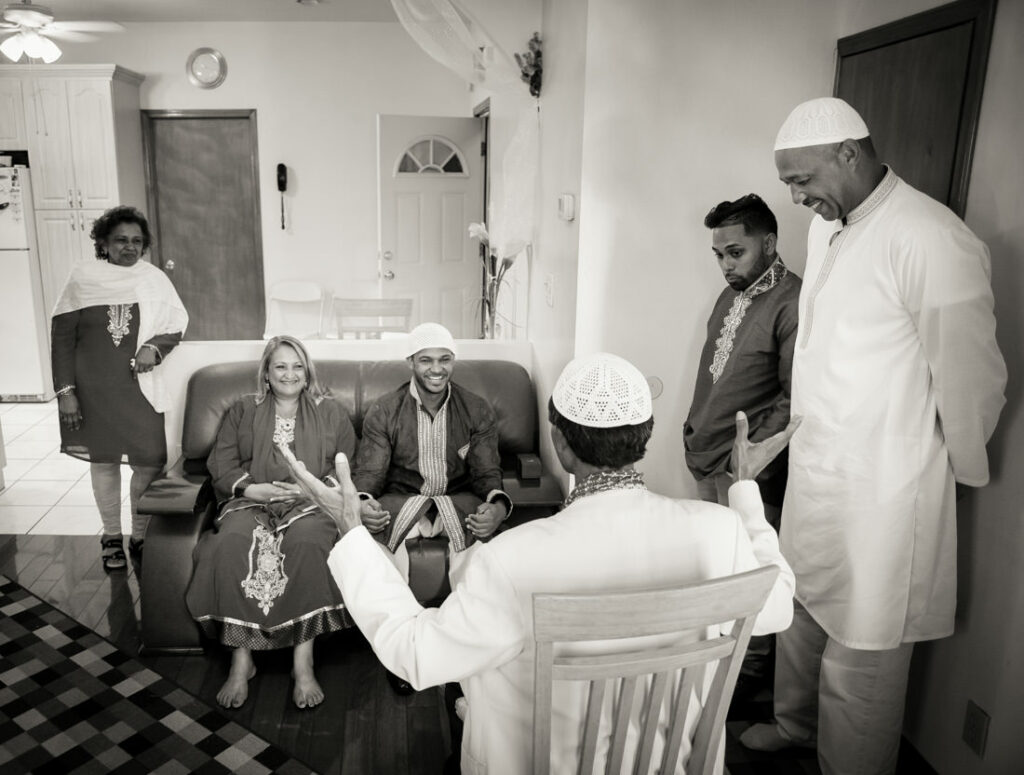 A group of people attending a nikah ceremony in a living room.
