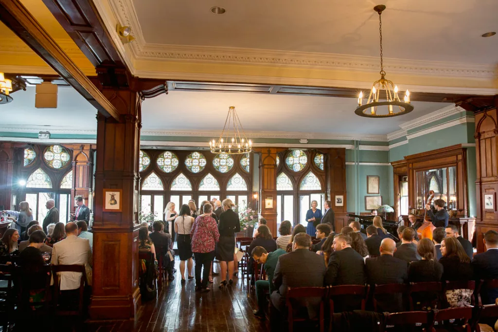 A wedding ceremony in a large room with many people.
