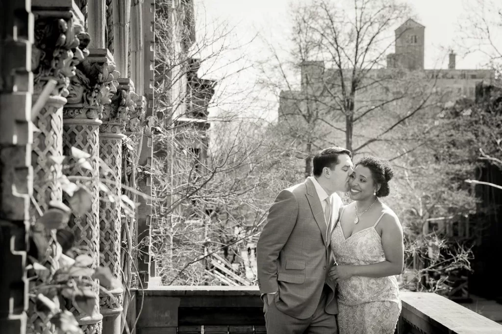 A black and white photo of a bride and groom on a balcony at The Montauk Club in Broklyn.