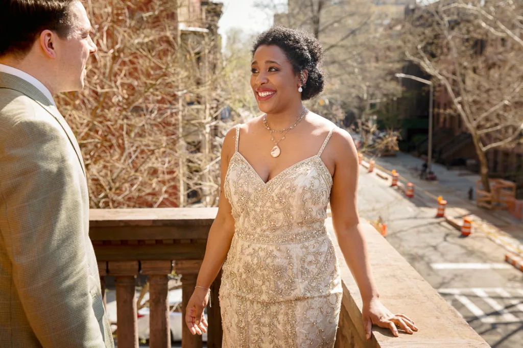 A bride and groom looking at each other on a balcony.