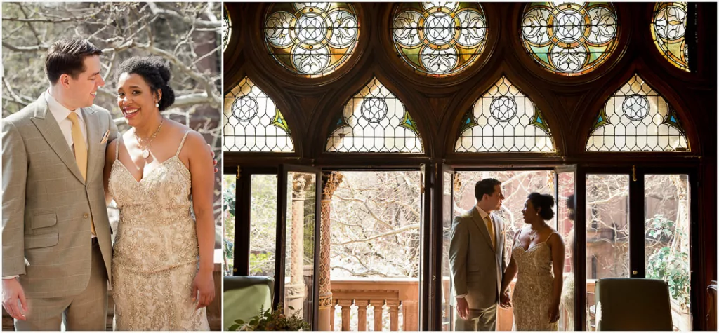 A bride and groom standing in front of a stained glass window.