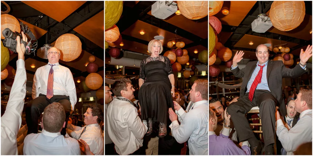 A group of people are being lifted up on a chair during the reception.