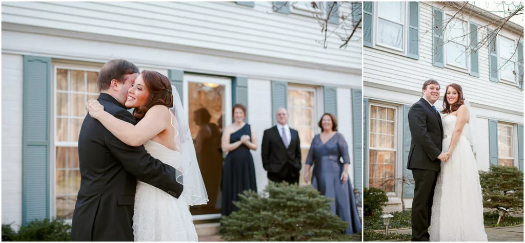 A bride and groom hugging in front of a their house.