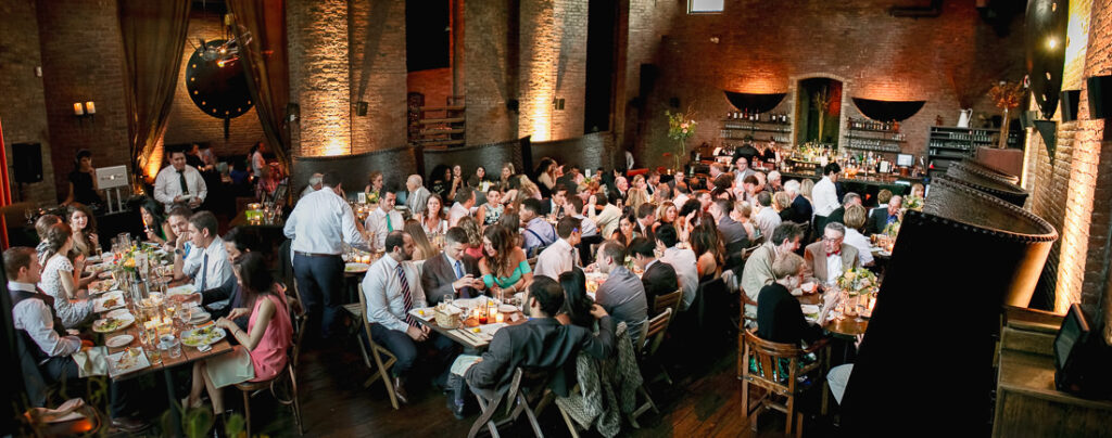 A large group of people at tables in a restaurant in Brooklyn.