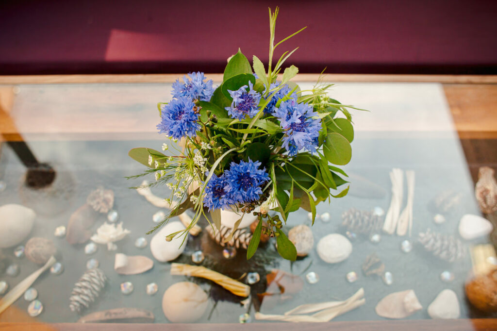 Blue flowers in a vase on a glass table.