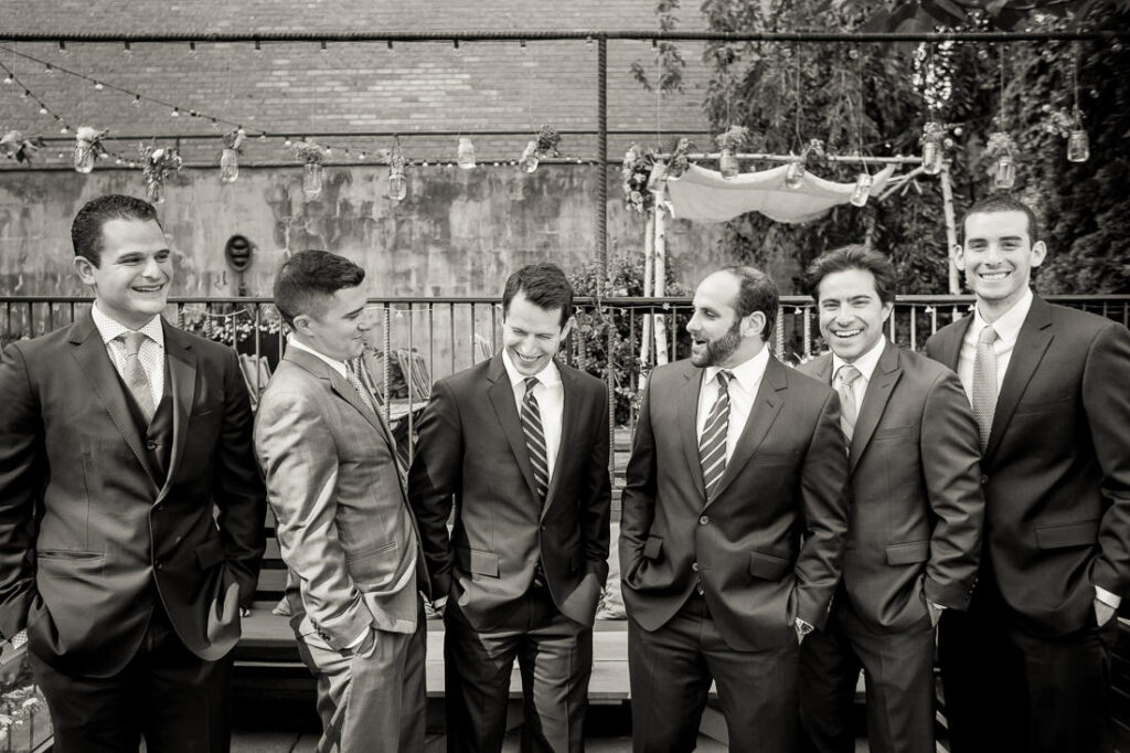A group of groomsmen in suits are posing for a photo at MyMoon.