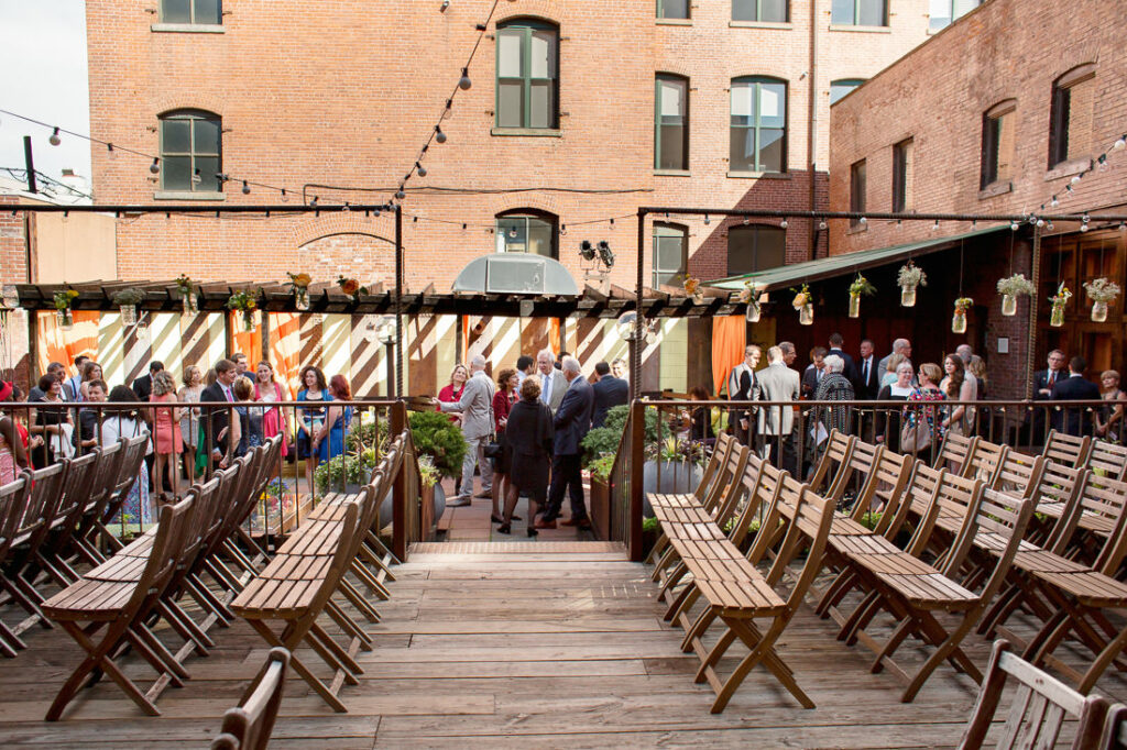 An outdoor wedding ceremony with chairs and tables.