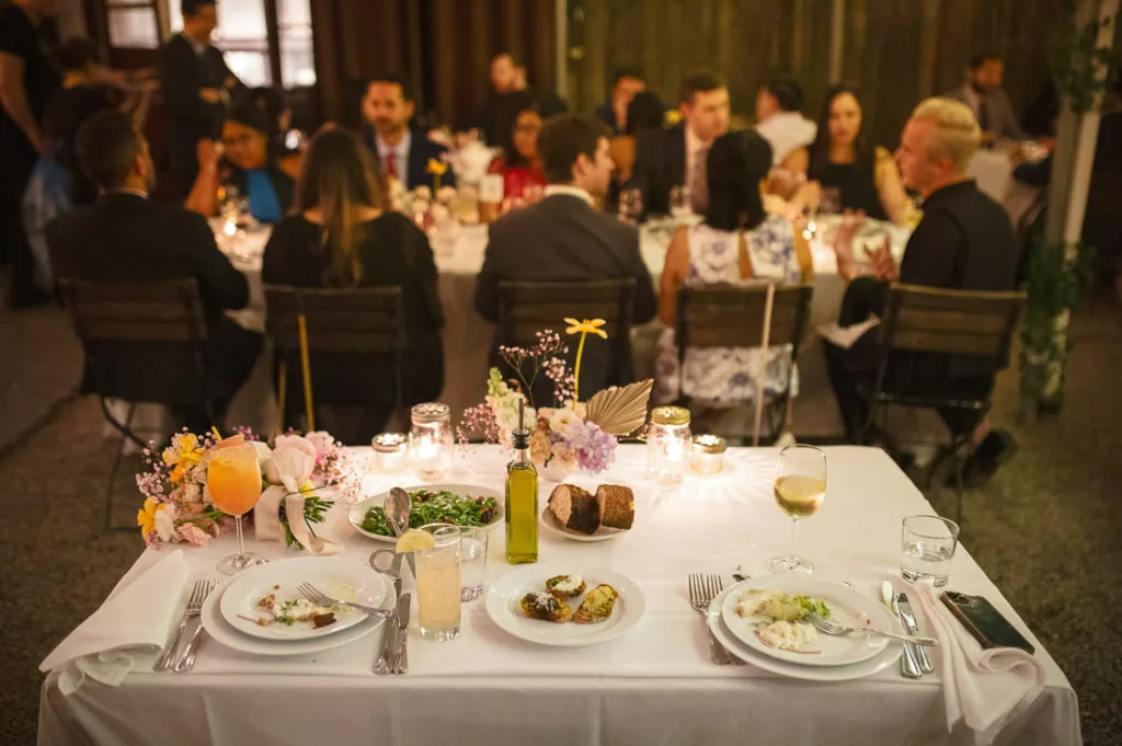 A group of people sitting around a table at a wedding reception at Frankies 457 Spuntino.
