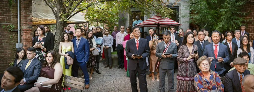 A group of people standing next to each other at a wedding ceremony.