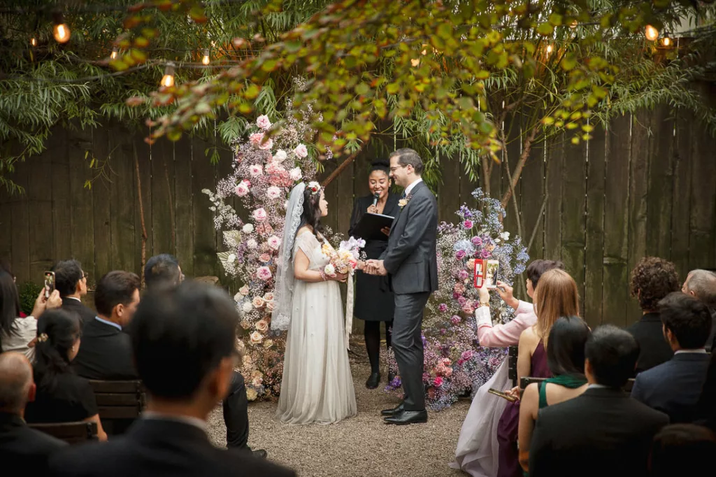 A bride and groom exchange vows in an outdoor ceremony at Frankies 457 Spuntino.