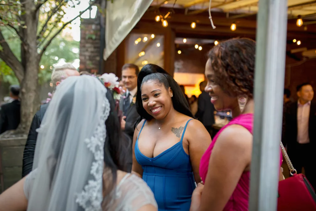 A bride and her bridesmaids talking at an outdoor wedding at Frankies 457 Spuntino.