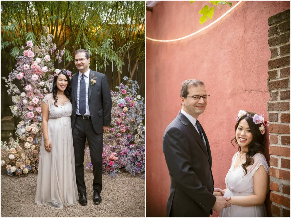 A bride and groom standing in front of a brick wall.