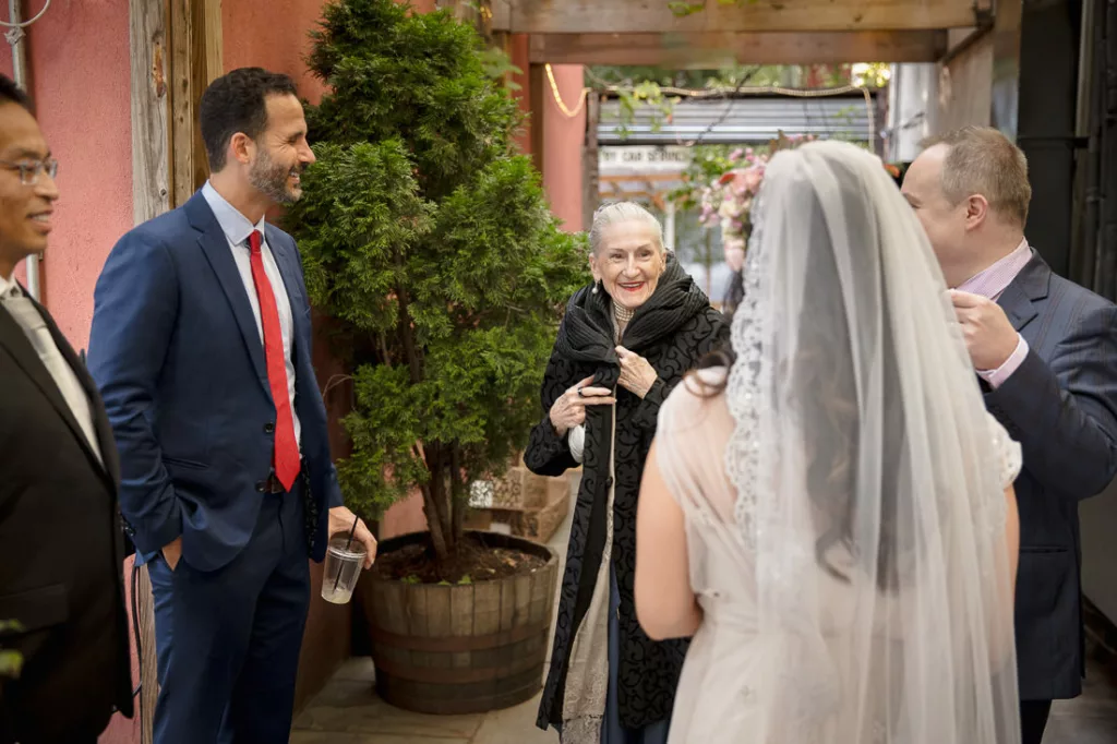 A bride and groom talking to each other in a courtyard.